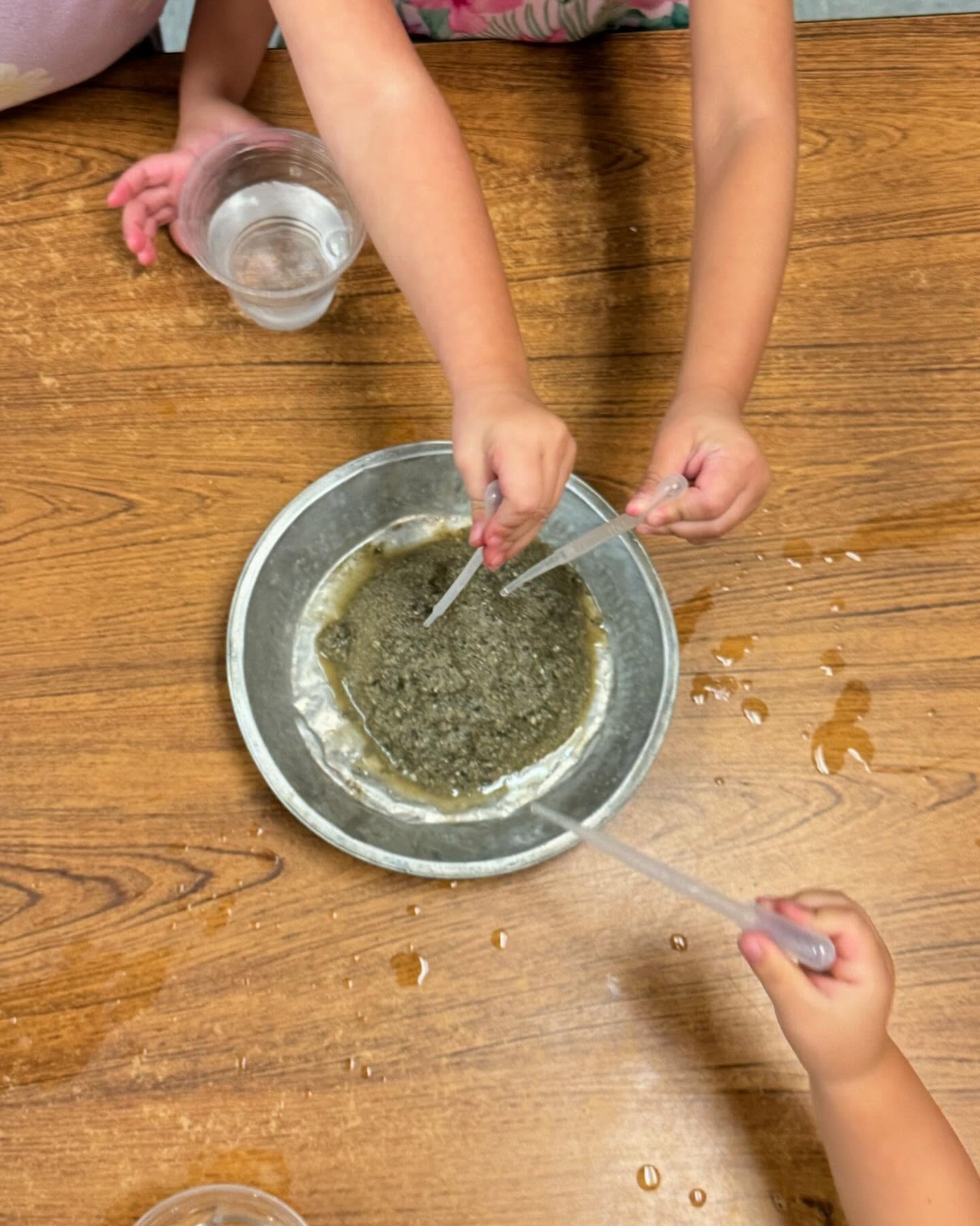 Children using pipettes in a hands-on water and sand science experiment
